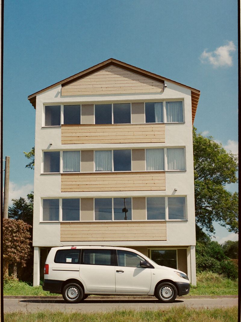 Modern aparthotel met houten gevelbekleding in een groene buitenwijk