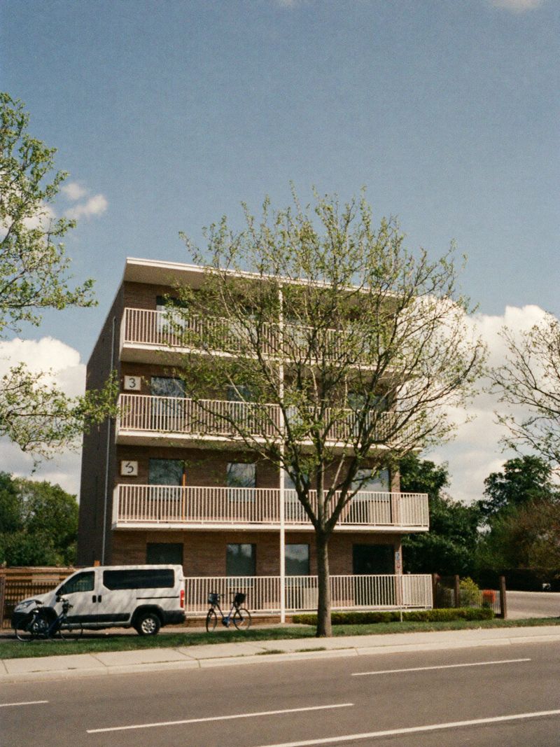Modern bakstenen appartementengebouw met balkons in een rustige straat